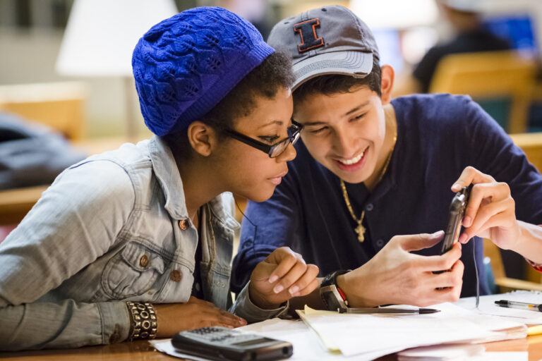 Students looking at phone in Grainger Engineering Library