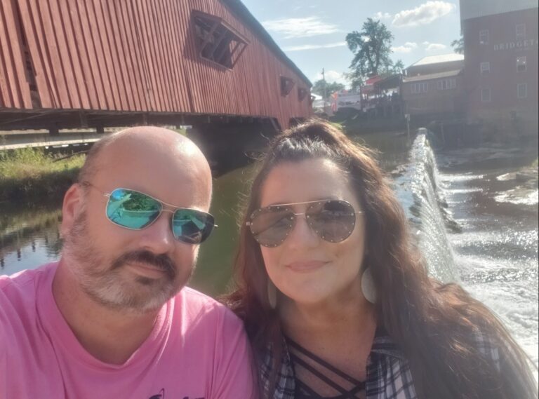 An image of Shawn and his wife, Christine, smiling in sunglasses