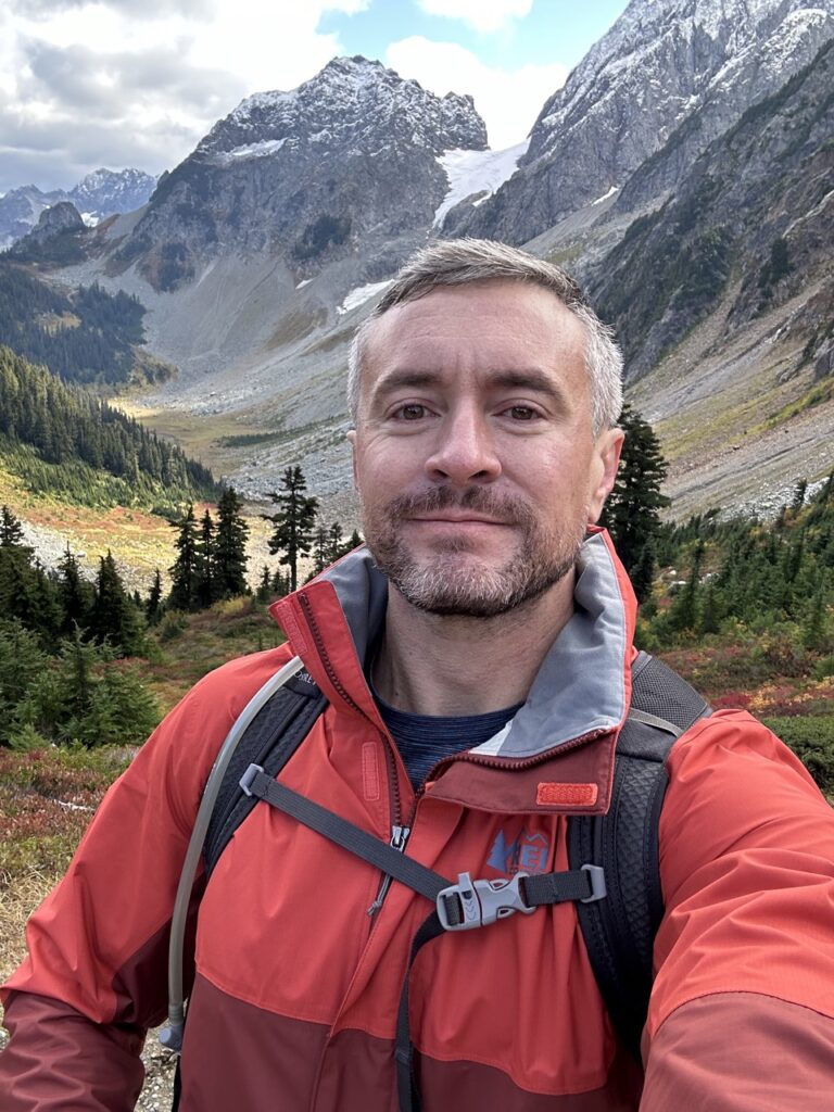 Stephen Butler smiling while hiking in the mountains