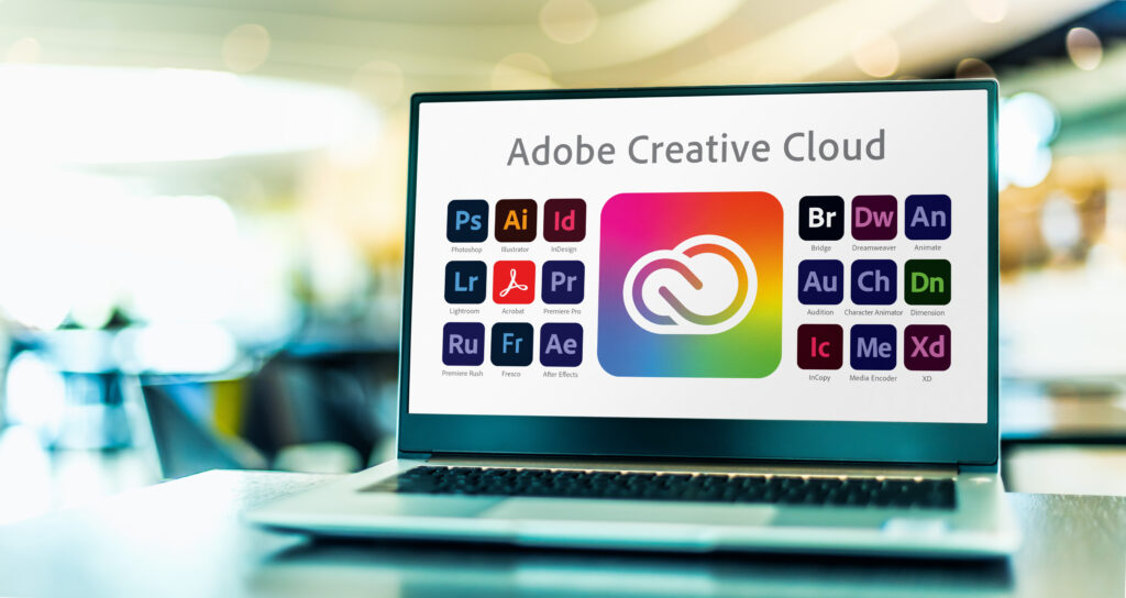 Laptop computer displaying logotypes of Adobe Creative Cloud